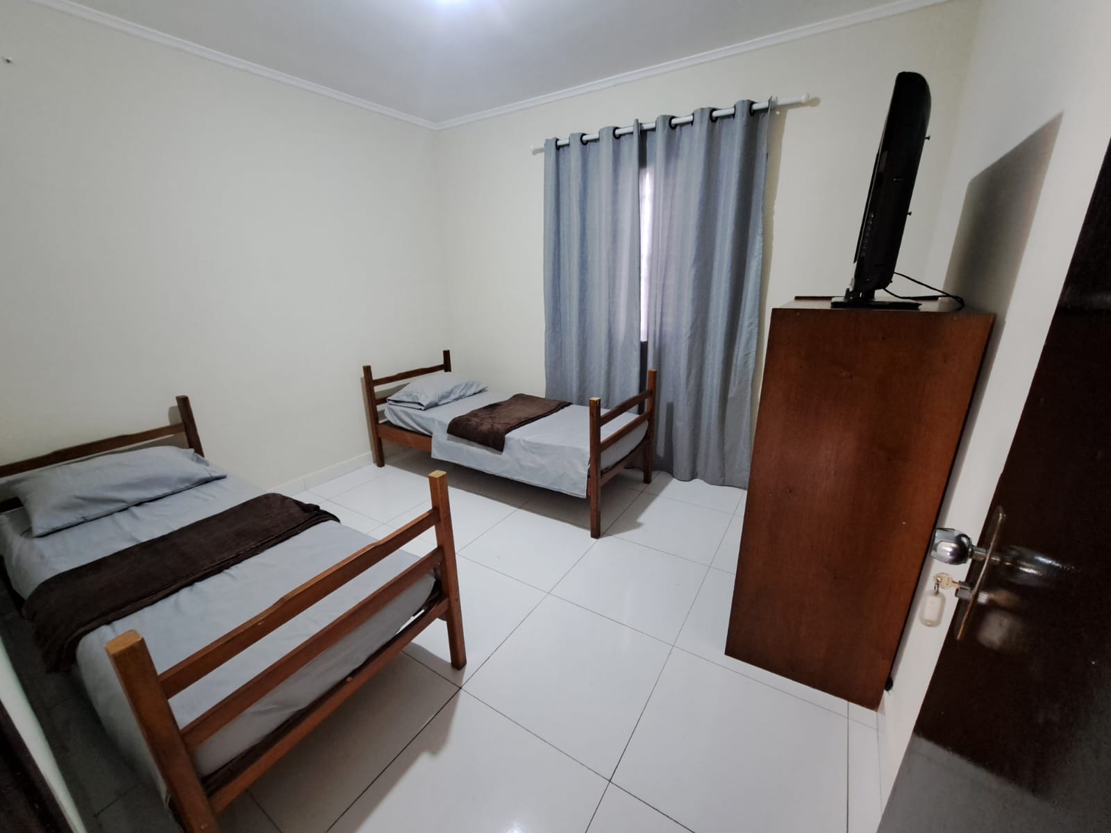 Quarto com uma cama de solteiro e uma cama de casal